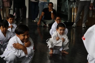 Niños practicando karate en piso oscuro
