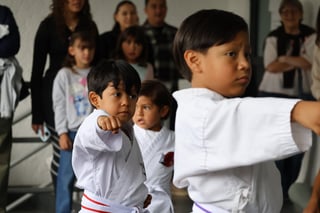Niños practicando técnicas con instructores observando