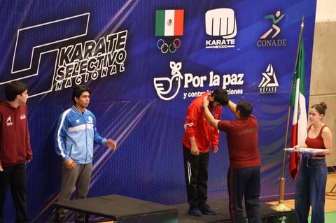 Karate championship awards ceremony with athletes receiving medals on stage, Mexican flag and sponsor logos visible on blue backdrop