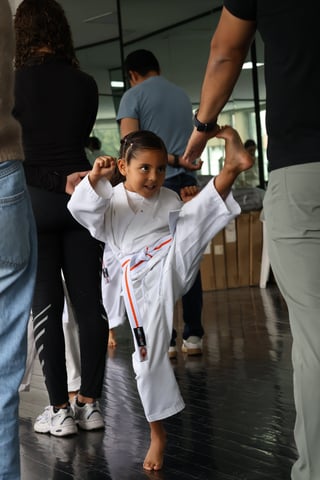 Niño siendo levantado por manos de adultos