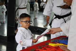 Niño recibiendo cinturón de instructor